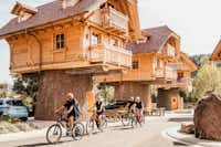 Ferienparadies Schwarzwälder Hof Gäste beim Radfahren durch das Baumhaus Dörfle mit außergewöhnlichen Mietunterkünften