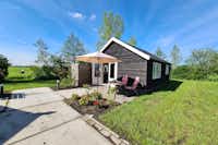 Minicamping De Kan Hoeve - Mobilheim mit kleiner Terrasse und Sonnenschirm
